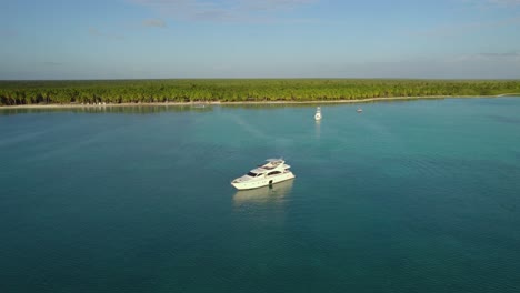 Luftaufnahme-Nähert-Sich-Einer-Yacht-An-Der-Küste-Von-Punta-Cana,-Sonnenuntergang-In-Der-Dominikanischen-Republik