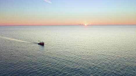 Fliegen-über-Meereslandschaft-Und-Einsamer-Trawler-Bei-Sonnenuntergang