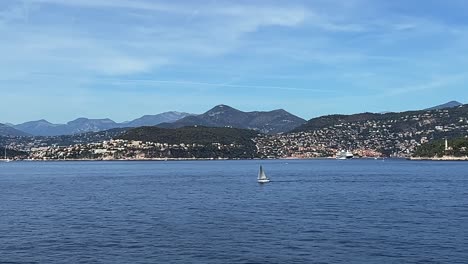 Sailboat-sailing-along-coast-of-Nice-in-France,-panning-view