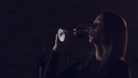 Eine-Dame-Trinkt-Langsam-Und-Genießt-Ihr-Glas-Roten-Brasilianischen-Weins-Vor-Einem-Dunklen-Hintergrund---Nahaufnahme