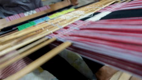 Close-up-of-Timorese-women-skilfully-working-on-making-a-traditional-cultural-colourful-tais-woven-fabric-on-a-loom-in-Timor-Leste,-South-East-Asia