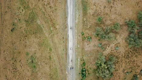 Drone-view-from-above-of-a-group-of-cyclists-riding-along-a-rural-road-in-kenya