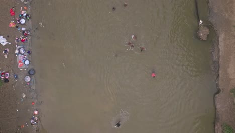 Aerial-top-down-shot-of-HAITIANS-Population-washing-clothes-in-River-ON-BORDER-DOMINICAN-REPUBLIC-WITH-HAITI