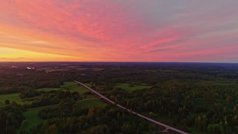 Picturesque-drone-panorama-over-green-forest-landscape-during-colorful-sunset-sky