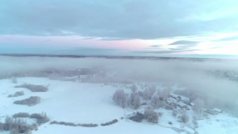 Snow-covered-landscape,-forest-shrouded-in-fog,-Winter-season-in-Norway---Aerial-dolly-shot