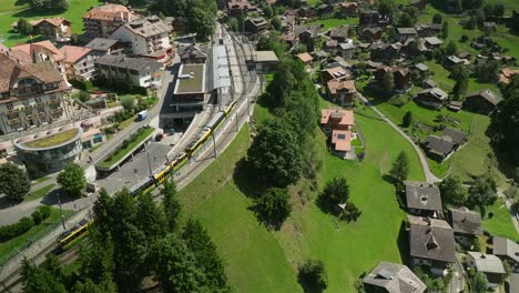 Aerial-view-of-the-Wengenalpbahn-ascending-to-the-station-in-Wengen,-Switzerland-2-of-3