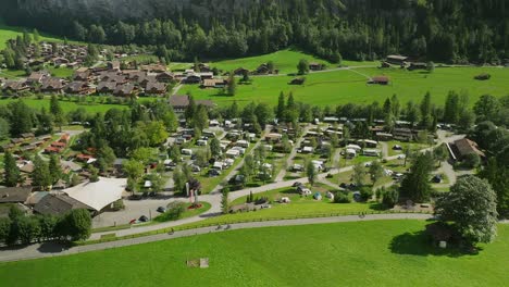 Aerial-views-of-cyclist-riding-by-camping-Jungfrau-in-Lauterbrunnen,-Switzerland