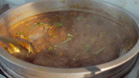 Garnieren-Des-Currys-Mit-Ingwer-Und-Curryblättern-In-Einem-Gefäß