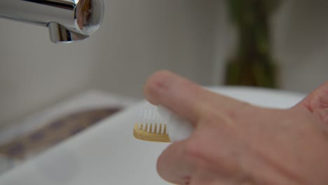 Applying-foam-on-a-tooth-brush,-close-up