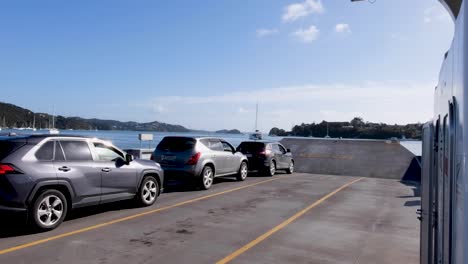 Vehículos-Estacionados-En-El-Transbordador-De-Pasajeros-Y-Automóviles-Que-Cruzan-A-La-Ciudad-De-Okiato,-Old-Russell-En-La-Bahía-De-Islas,-Nueva-Zelanda-Aotearoa