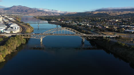 Early-Morning-Aerial-of-the-Columbia-River-in-Wenatchee-Washington---Bridge-with-Fog-in-Mountains