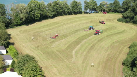 Aerial-view-of-tractor-and-combine-harvester-cutting-and-plowing-farm-field-beside-lake