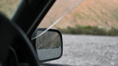 Video-of-the-car-rearview-mirror-looking-at-the-people-who-walking-in-the-rocky-terrain-in-Balochistan
