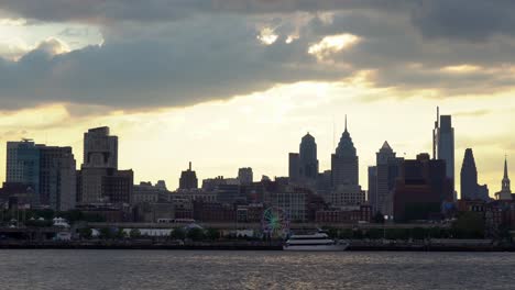 Philadelphia,-Pennsylvania---28.-August-2022:-Ein-Blick-Auf-Die-Skyline-Von-Philadelphia-Mit-Dem-Sonnenuntergang-Dahinter-Und-Dem-Fluss-Im-Vordergrund