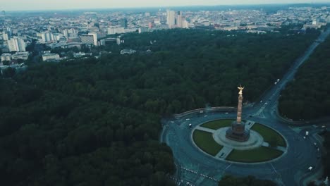 Drone-aerial-over-Berlin-Victory-Column-during-sunrise-slow-pan-down-with-cars-on-road