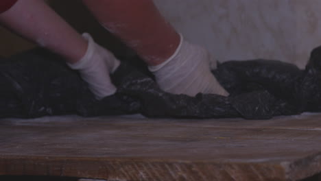 Roher-Teig-Auf-Holztisch-Mit-Schwarzem-Kunststoff-Bedeckt
