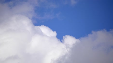Zeitraffer-Von-Weißen,-Flauschigen-Wolken,-Die-Mit-Blauem-Himmelshintergrund-Vorbeirollen