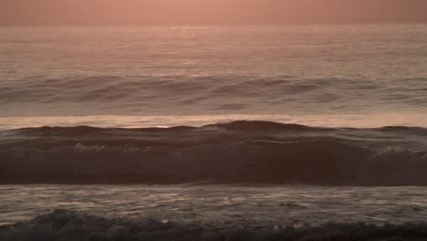 Nahaufnahme-Der-Wellen,-Die-Im-Goldenen-Sonnenuntergangslicht-Am-Strand-Rollen