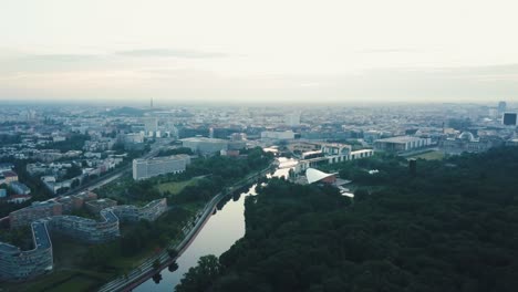 Drohnenschwenk-Nach-Links-In-Richtung-Berlin-City-Mit-Einem-Fluss-Bei-Sonnenaufgang