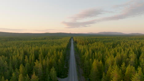 Camino-Interminable-En-Medio-De-Bosques-De-Abetos-Durante-La-Puesta-De-Sol-En-Laponia,-En-El-Norte-De-Suecia