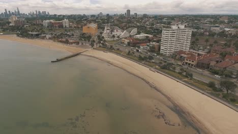 Drone-aertial-over-the-beach-in-St-Kilda-showing-the-beach,-Luna-park-and-skate-park