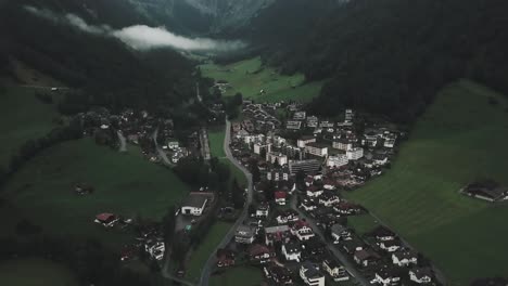 Drone-aerial-pan-down-over-Endelberg-in-Switzerland-to-show-traditional-houses-and-buildings-on-grasslands