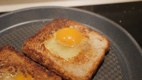 Close-up-of-homemade-fried-egg-on-a-toast-in-frying-pan