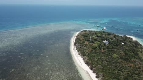 Paneo-Aéreo-De-Drones-Hasta-La-Gran-Barrera-De-Coral-Y-La-Isla-Tropical-Con-Botes-En-El-Agua-Azul-Clara