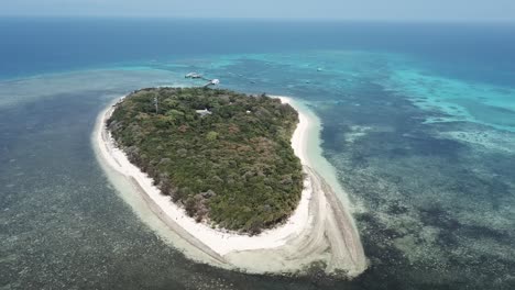 Drohnenschwenk-Um-Eine-Kleine-Tropische-Insel-Mit-Bäumen-Und-Blauem,-Klarem-Wasser