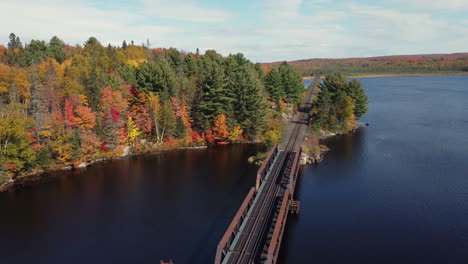 Circling-around-a-railway-bridge-to-reveal-more-of-the-autumn-forest-and-kayaks