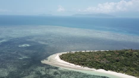Drohnenantenne,-Die-In-Richtung-Einer-Grünen-Tropischen-Insel-Mit-Bäumen-Auf-Klarem-Blauem-Wasser-Schwenkt