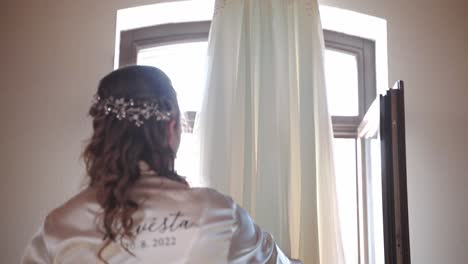 Braut-Im-Kleid,-Das-Ihr-Hochzeitskleid-Bewundert,-Das-Vom-Deckenbalken-Hängt