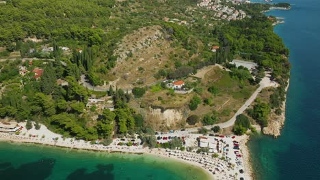 Aerial-reveal-of-Kasjuni-beach-and-Marjan-Hill-in-Split,-Croatia