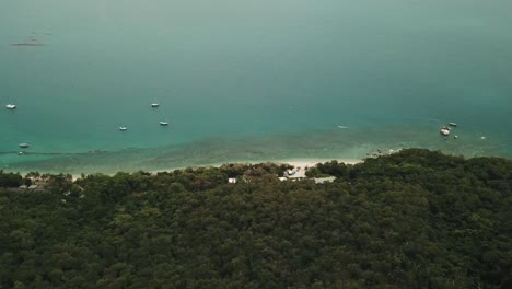 Drohne-Langsame-Luftschwenk-über-Tropische-Insel-Mit-Klarem-Blauem-Wasser-Mit-Booten