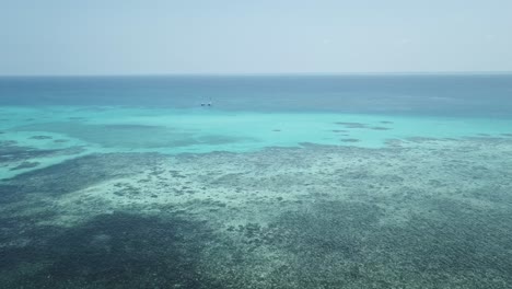 Drone-aerial-pan-around-over-the-Great-Barrier-Reef-with-boats-on-the-tropical-clear-blue-water