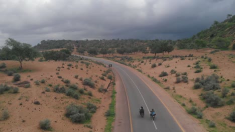 Drone-Toma-Una-Toma-Aérea-De-La-Carretera-En-Tharparkar-Ubicada-En-Sindh-Donde-Dos-Motociclistas-Conducen-Su-Bicicleta