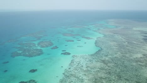 Drone-aerial-pan-down-on-the-great-barrier-reef-that-has-tropical-blue-water
