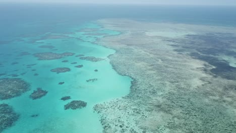Drone-aerial-pan-up-on-the-great-barrier-reef-that-has-tropical-blue-water
