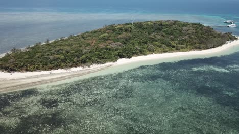 La-Antena-Del-Dron-Se-Mueve-Hacia-Atrás-Lentamente-Para-Revelar-La-Isla-Tropical-Del-Bosque-Verde-El-Océano-Azul-Claro-Del-Arrecife