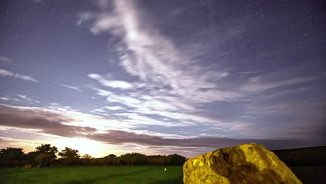 Timelapse-of-clouds-by-green-fields-and-starry-sky-getting-brighter