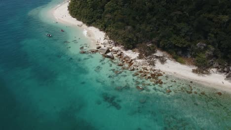 Drone-aerial-over-tropical-clear-blue-water-on-Fitzroy-Island-with-trees