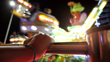 Point-of-view-watching-an-amusement-park-carnival-ride-lit-up-at-night