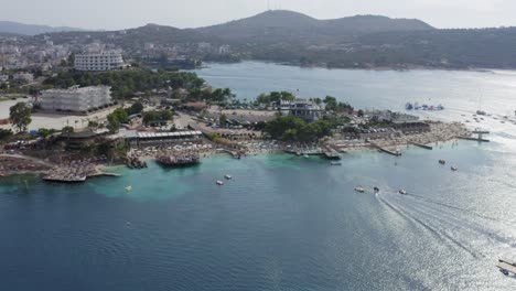 Ksamil-Coastline-on-Albanian-Riviera-with-beach-clubs-and-water-toys,-meditteranean-ocean