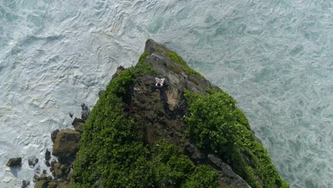 Aerial-top-view-of-man-while-he-is-sitting-on-the-edge-of-a-cliff