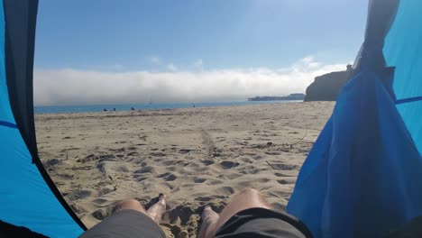 Las-Piernas-De-Un-Hombre-Colgando-De-Una-Carpa-Disfrutando-De-La-Playa-Sunny-Beach-En-Santa-Cruz,-California