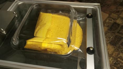 Vacuum-packing-yellow-pumpkin-puree-inside-a-glass-top-vacuum-machine