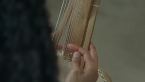 Female-hands-playing-Kora-African-harp-in-a-warm-day-light-ambient,-close-ups-shot