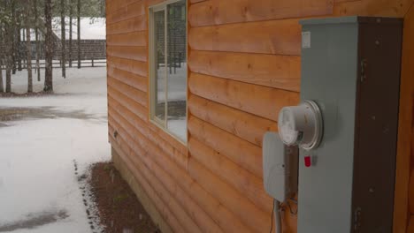 The-side-of-a-cabin-and-the-electrical-box-in-the-snow