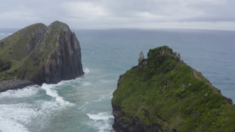 Drone-flying-over-high-green-rocky-cliffs-in-ocean,-Wild-coast-Transkei