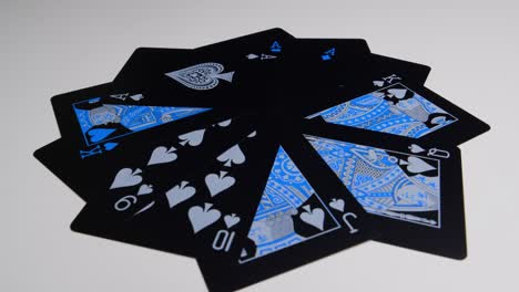 Rotating-Shot-of-black-cards-in-circle-laying-on-white-surface
